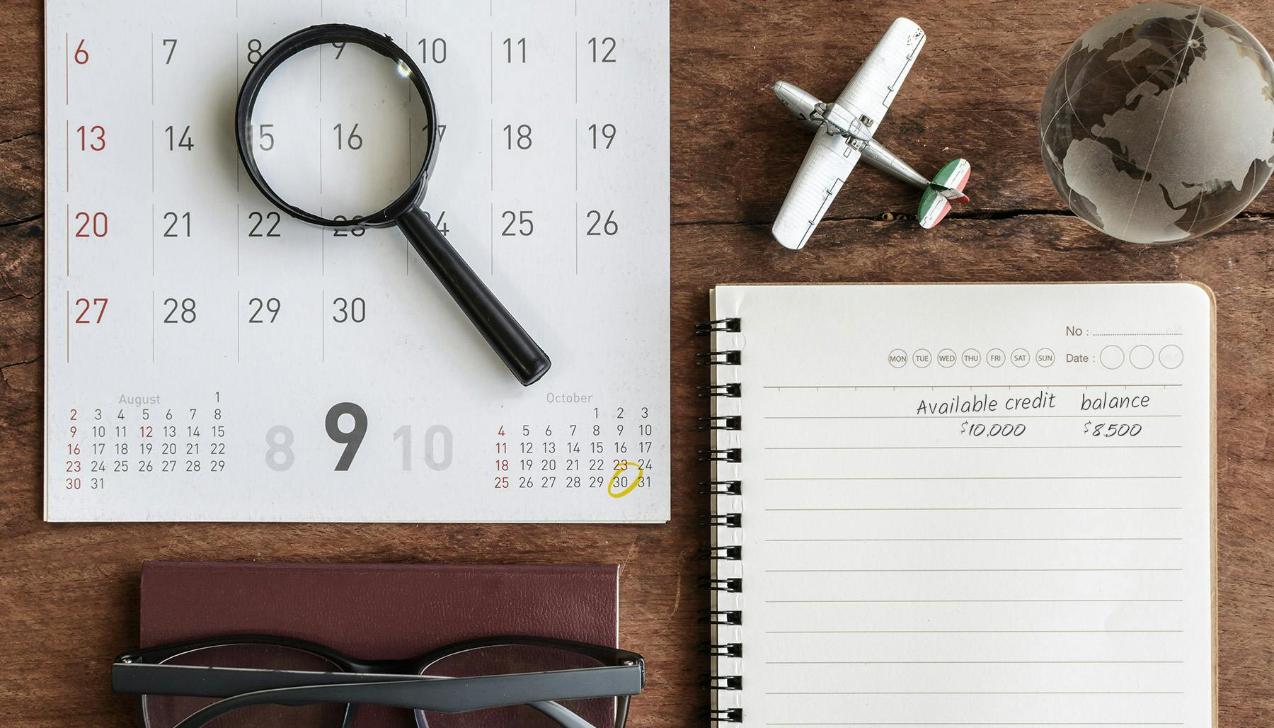 Table with a calendar, magnifying glass, model airplane, and eyeglasses